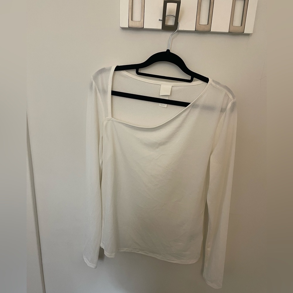Sophisticated long sleeve with a symmetrical neckline. Eggshell color